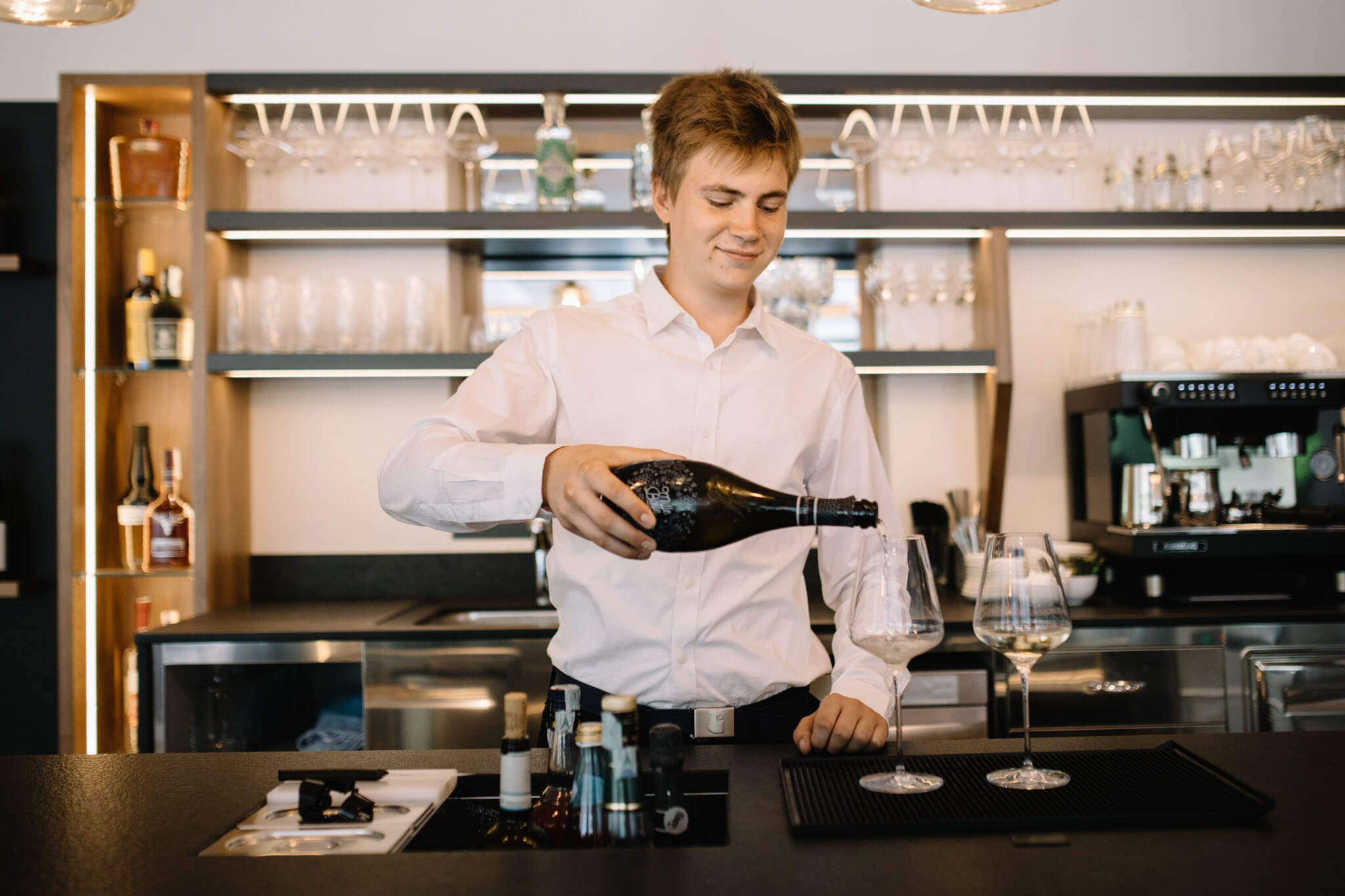 Service employee pouring prosecco